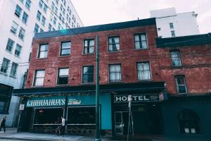 un edificio de ladrillo en una calle de la ciudad con un hotel en The Cambie Hostel Seymour en Vancouver