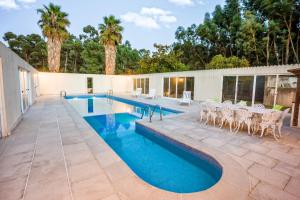 a swimming pool with tables and chairs on a patio at Casa da Quinta Nova in Valença