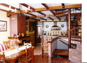 a kitchen with a table and a stove top oven at Casa ALPULUSO in Arroyo Frio +5 photos