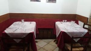 Valentano的住宿－SUITE-TTI，餐厅里有两个桌子,有红白桌布