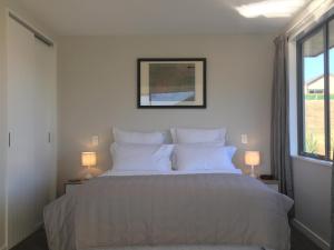 ein Schlafzimmer mit einem großen Bett mit weißen Kissen in der Unterkunft Minaret Ridge Retreat in Wanaka