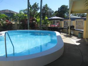 a swimming pool with a pool table and chairs at Sunburst Motel in Gold Coast