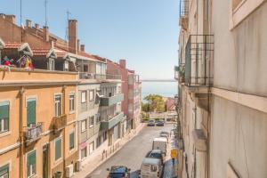 a view of a city street with buildings and the water at Rua Washington Lisbon in Lisbon