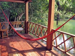 a porch with a hammock and a view of a river at Campamento Rio Lacanja in Lacanjá