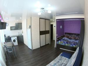 Habitación pequeña con cama y cocina en Apartment on Lenina 44 en Komsomolsk-na-Amure