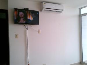 a flat screen tv hanging on a white wall at Arena Plaza Tonsupa in Tonsupa