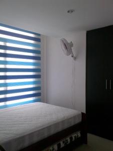 a bedroom with a bed and a window with a fan at Arena Plaza Tonsupa in Tonsupa +11 photos