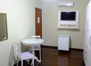 Habitación pequeña con mesa, sillas y TV. en Pousada Apricare, en Cabo Frío 33 fotos más