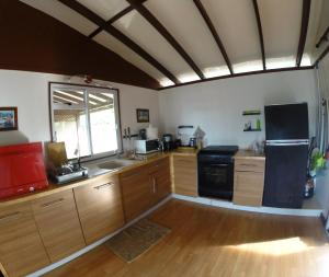 uma grande cozinha com armários de madeira e uma janela em Otemanu Ninamu Fare em Bora Bora