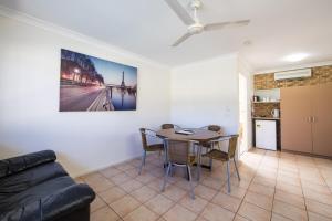 a living room with a table and a couch at Caboolture Motel in Caboolture