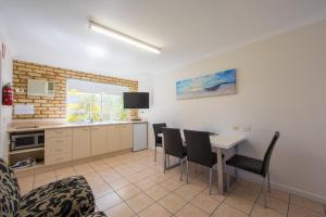 a kitchen and dining room with a table and chairs at Caboolture Motel in Caboolture