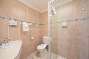 a bathroom with a toilet and a sink at Caboolture Motel in Caboolture +25 photos