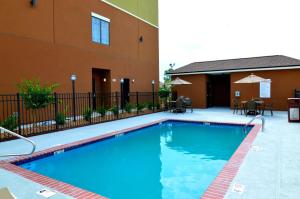 a swimming pool in front of a building at Best Western False River Hotel in New Roads
