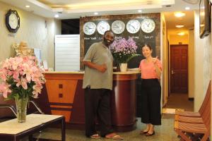 a man and a woman standing at a counter with flowers at Sao Nam Hotel - Bui Vien Walking Street in Ho Chi Minh City