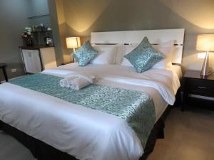 1 dormitorio con 1 cama blanca grande con almohadas azules en Kav's Beach Resort, en Zamboanguita