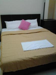 a bed with two white and pink pillows on it at Alisa Homestay in Sungkai