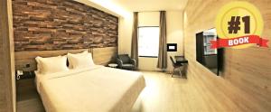 a hotel room with a bed and a brick wall at Hotel Legend Boutique in Johor Bahru