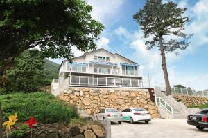 ein Gebäude mit davor geparkt in der Unterkunft Seasidepine Pension in Yeosu