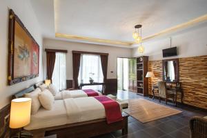 una camera da letto con un letto grande in una stanza di Ubud Raya Boutique Hotel ad Ubud