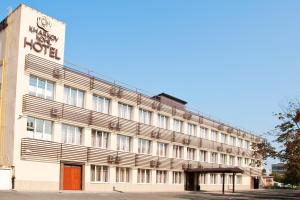 un edificio de hotel con un cartel en la parte delantera en Kapu$ta Hotel en Járkov