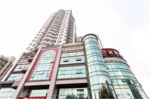 un edificio alto con finestre in vetro sopra di GreenTree Jiangsu Suzhou Shilu Walk Street West Ganjiang Road Shell Hotel a Suzhou