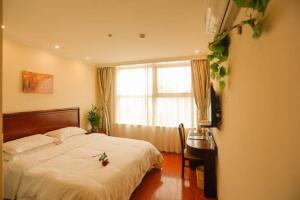 um quarto com uma cama, uma secretária e uma janela em GreenTree Jiangsu Suzhou Shilu Walk Street West Ganjiang Road Shell Hotel em Suzhou