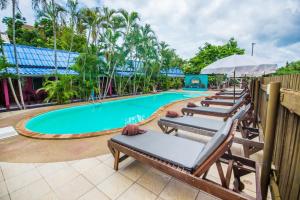 - une rangée de chaises longues à côté de la piscine dans l'établissement Pongphen Guesthouse - SHA Plus Certified, à Kanchanaburi