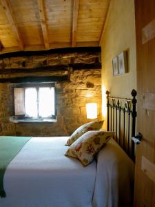 a bedroom with a bed with a stone wall at Casas Rurales El Mayorazgo in Cordovilla de Aguilar