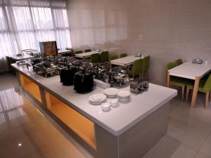 - une cuisine avec un comptoir avec des casseroles et des poêles dans l'établissement GreenTree Inn Hefei Feidong New District Huishang City Express Hotel, à Feidong