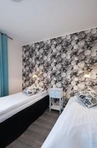 two beds in a room with a stone wall at Bjurfors Hotell & Konferens in Avesta