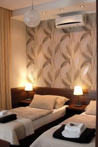 モハーチにあるCentrum Panzióのベッド2台と壁画が備わるホテルルームです。