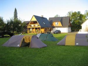 a group of tents in the grass in front of a house at Aare Accommodation in Valga