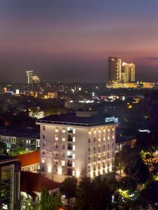 a lit up building in front of a city at night at Amaris Hotel Darmo Surabaya in Surabaya