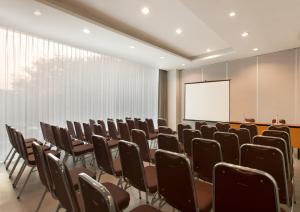 a conference room with chairs and a projection screen at Amaris Hotel Darmo Surabaya in Surabaya