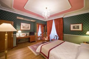 a bedroom with a bed and a desk at Strozzi Palace Hotel in Florence