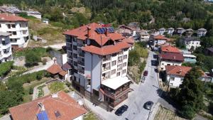 widok na budynek z czerwonym dachem w obiekcie Hotel Uzunski w mieście Smolan