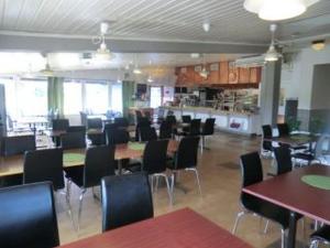 una sala da pranzo con tavoli e sedie in un ristorante di 17 Rum och Kök a Harmånger