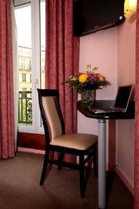 a room with a desk with a laptop and a chair at Hôtel Alane in Paris