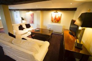 a living room with two white couches and a tv at Hornsbury Mill in Chard
