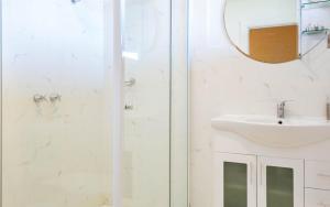 a bathroom with a shower and a sink and a mirror at Victor Apartments in Victor Harbor