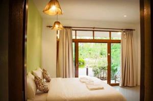 una camera con un letto e una grande finestra di Ruean Thai Nai Bang by PANSAK Resort a Suratthani