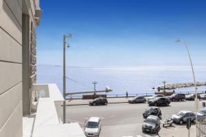 un estacionamiento con autos estacionados al lado del océano en Casa San Carlo, en Nápoles