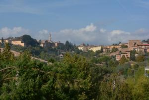 a town on a hill with houses and trees at Vittori Apartment in Siena