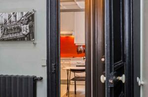 パリにあるLarge & Bright Apartment, Central Paris, Montmartre-Opéra, Picturesque Rue des Martyrsのテーブル付きのドアからキッチンの景色を望めます。