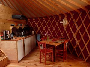 a kitchen with a table and chairs in a tent at Yourtes en Terrasse in Bonneval