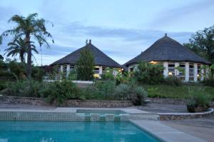 a house with a swimming pool in front of it at Musungwa Safari Lodge in Shanjungu