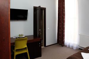 a bedroom with a desk and a yellow chair at City Club European in Chernivtsi