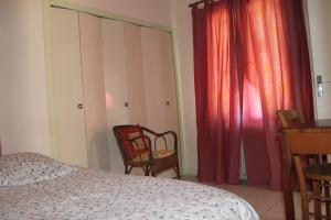 a bedroom with a bed and a chair and curtains at Appartement Val de Saône in Seurre