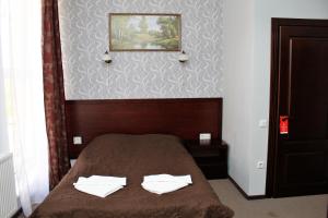 a bedroom with a bed with two white towels on it at City Club European in Chernivtsi