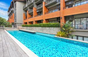 a swimming pool in front of a building at Rimnaam Klangchan Hotel - SHA Plus in Chanthaburi